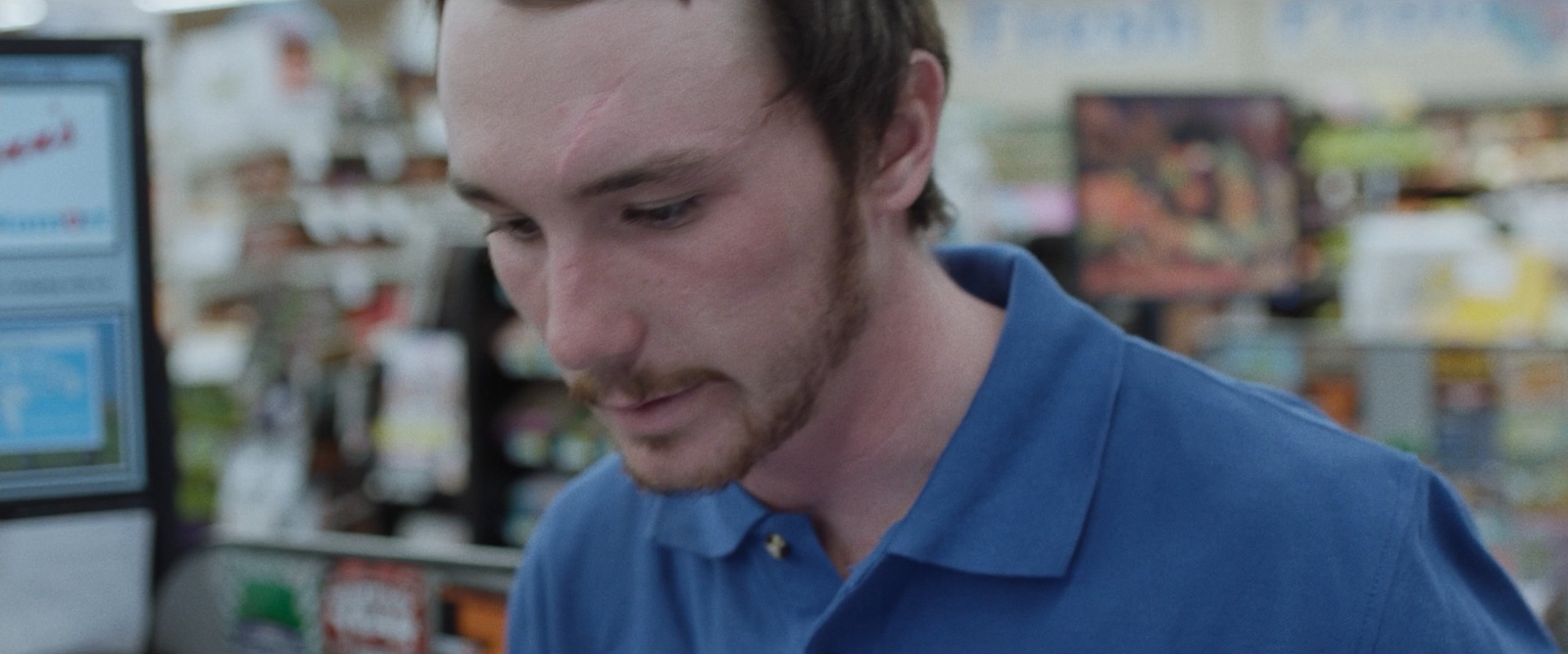 a man in a blue shirt looking at a cell phone