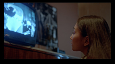 a young girl watching a movie on tv