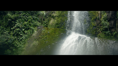 a large waterfall surrounded by lush green trees