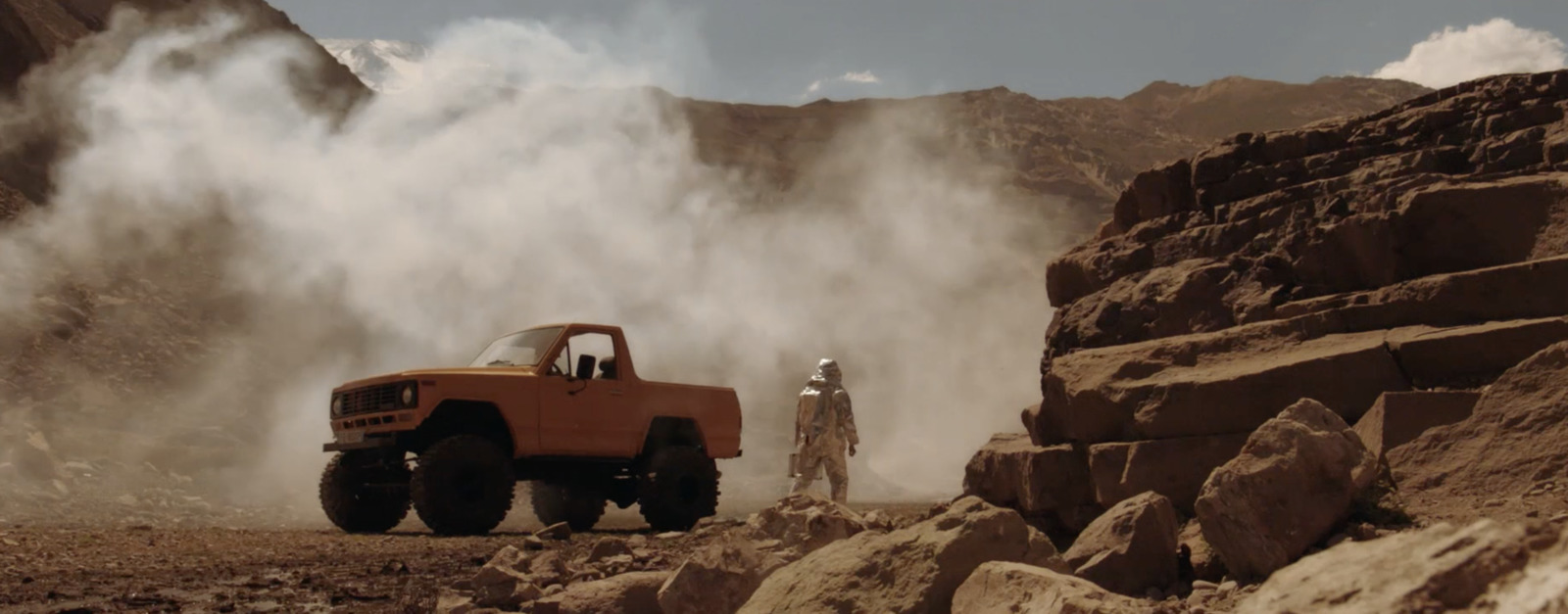 a red truck driving down a rocky road