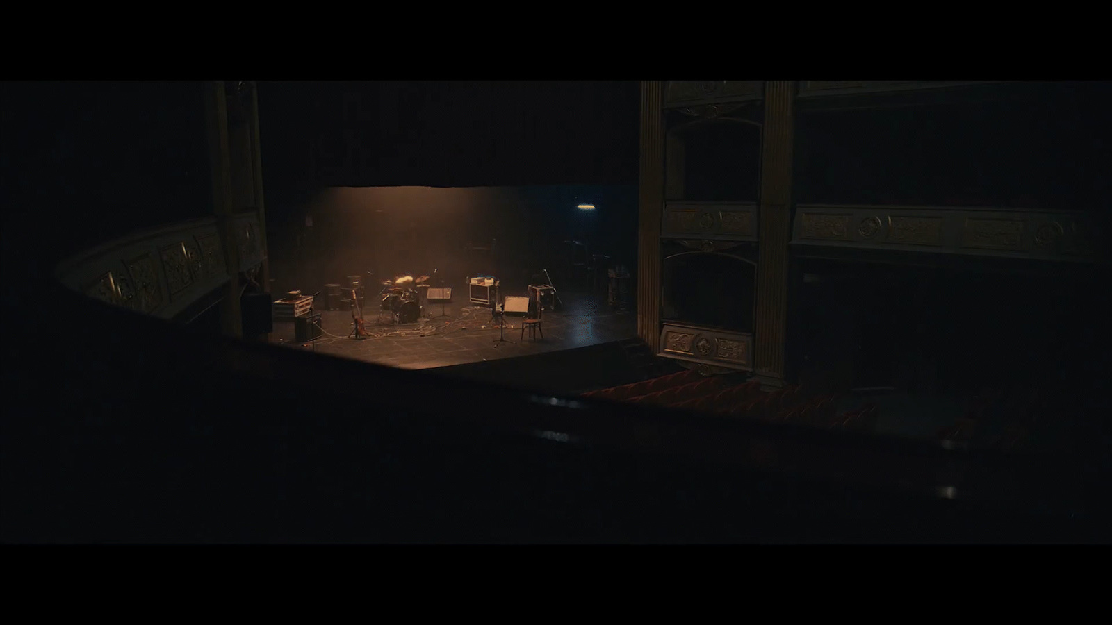 a dark stage with a group of people sitting at a table