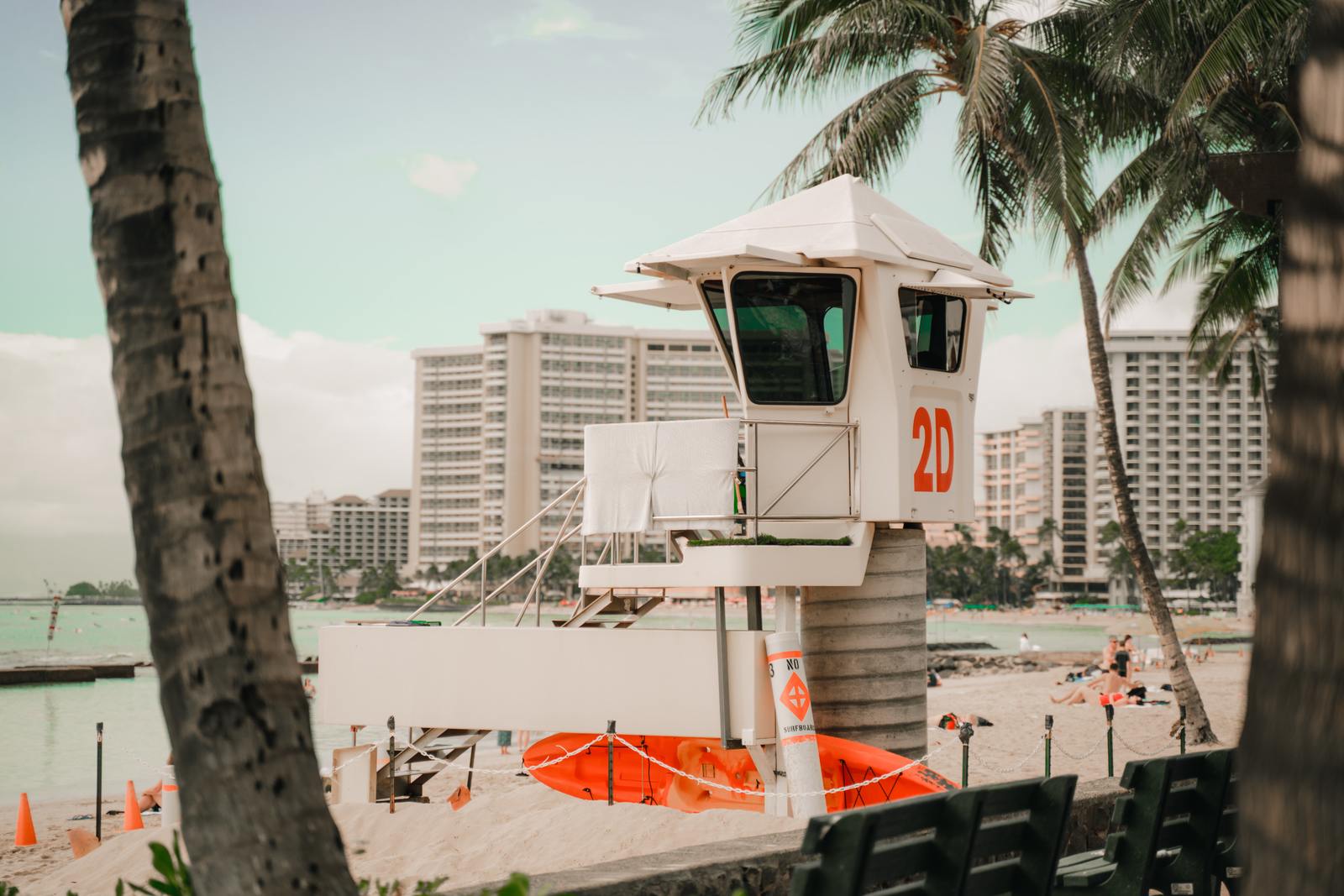 a lifeguard tower on a beach next to palm trees