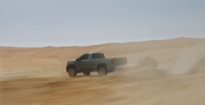 a black truck driving through a desert area