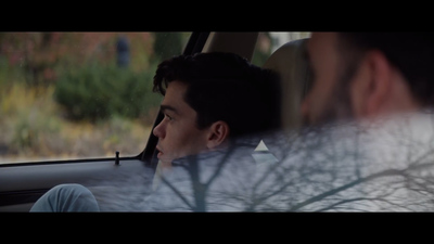 a man sitting in a car looking out the window