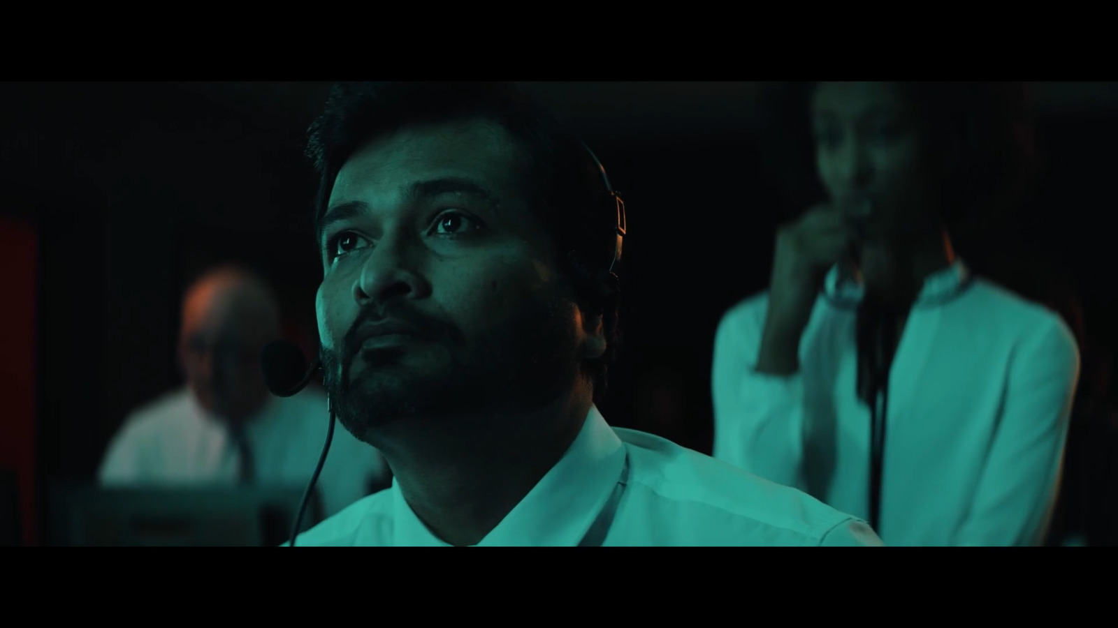 a man wearing a headset in a dark room