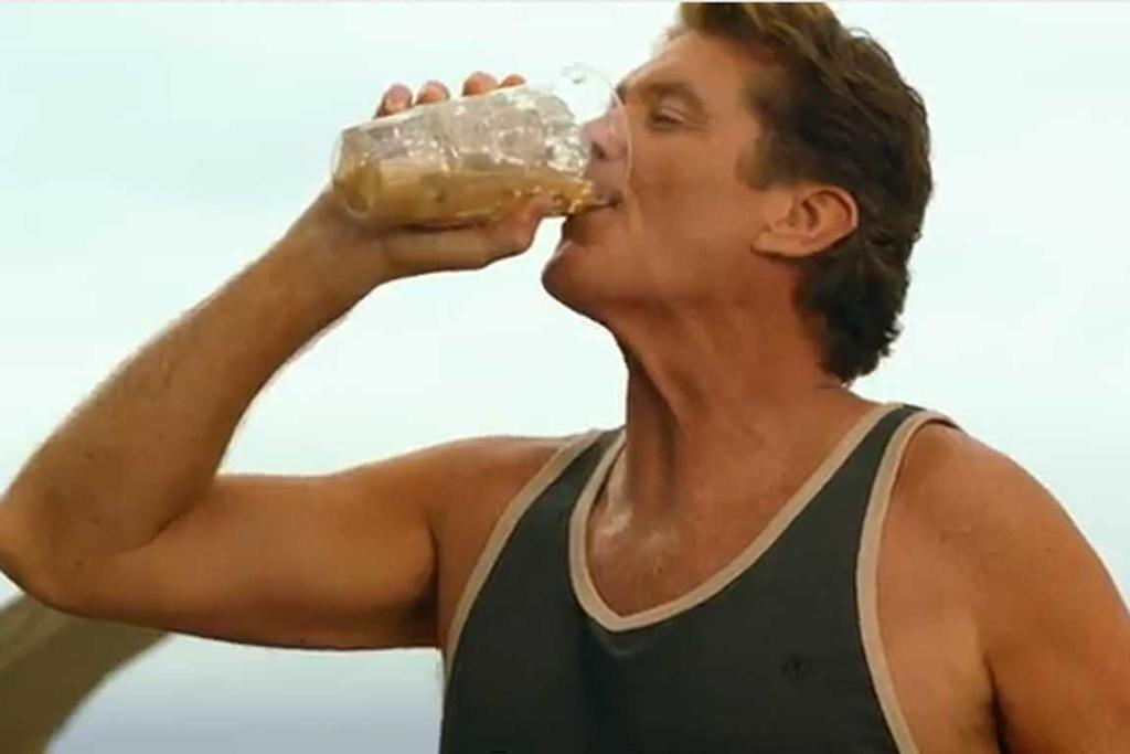 a man drinking a drink out of a plastic bottle