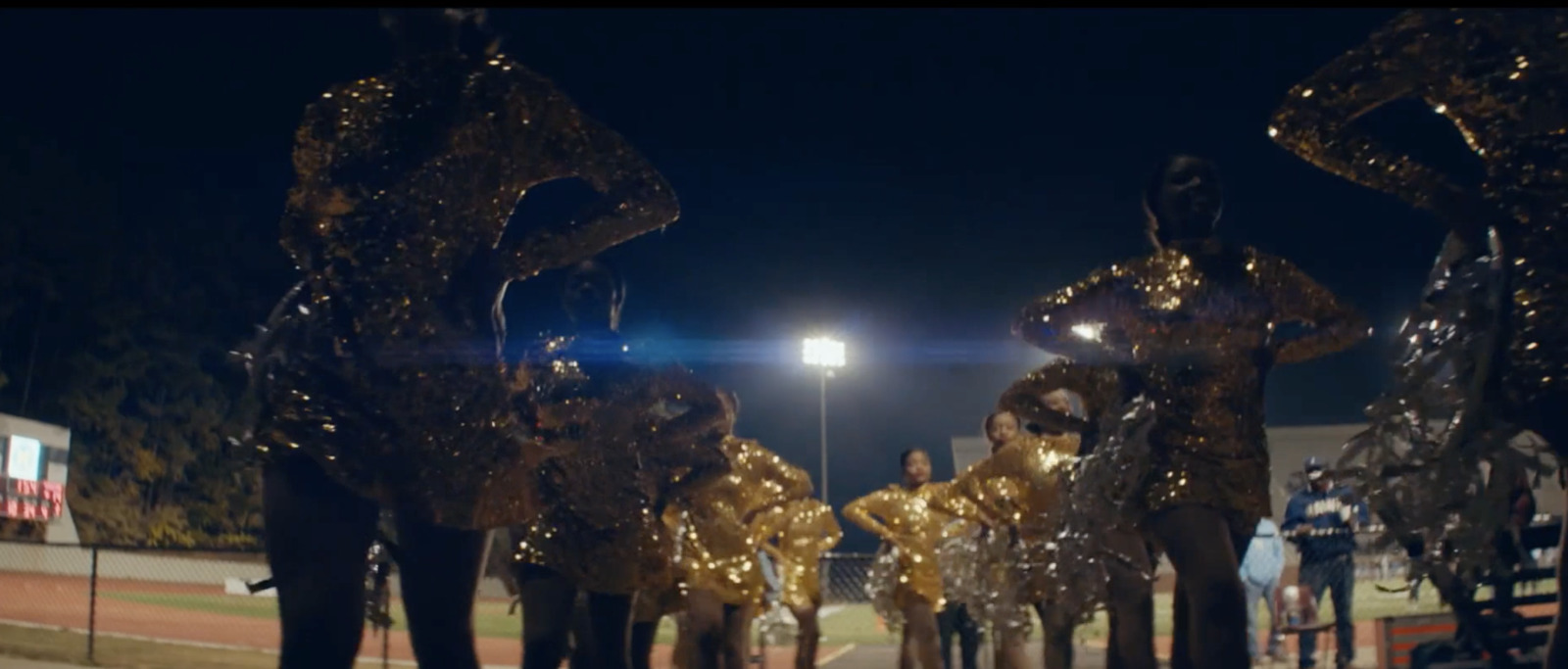 a group of people in shiny gold outfits