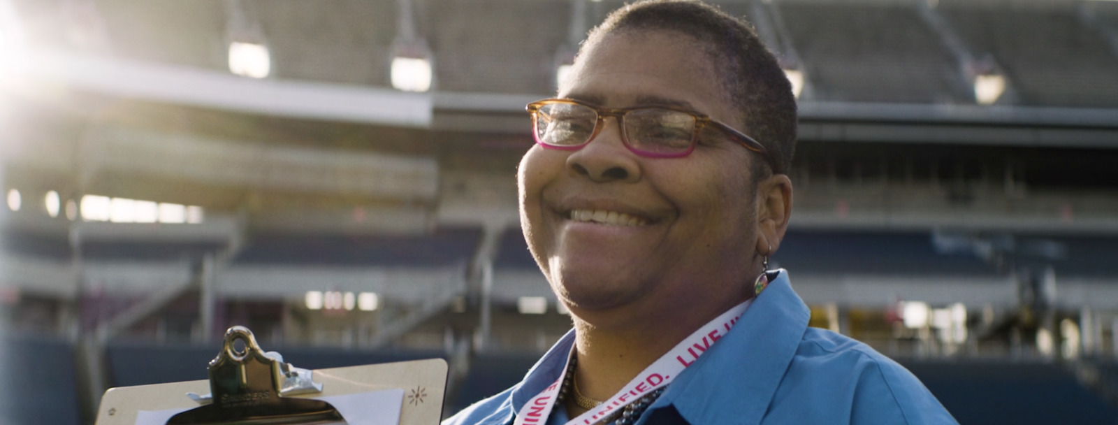 a woman in a blue shirt holding a trophy