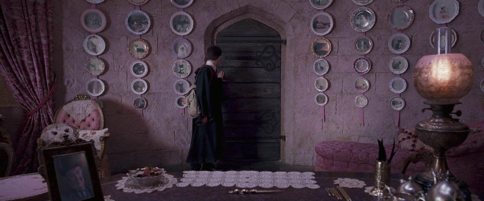 a woman standing in a room with plates on the wall