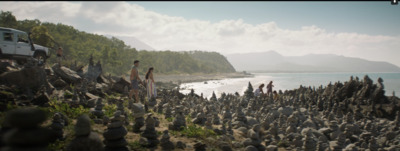 a group of people standing on top of a rocky beach