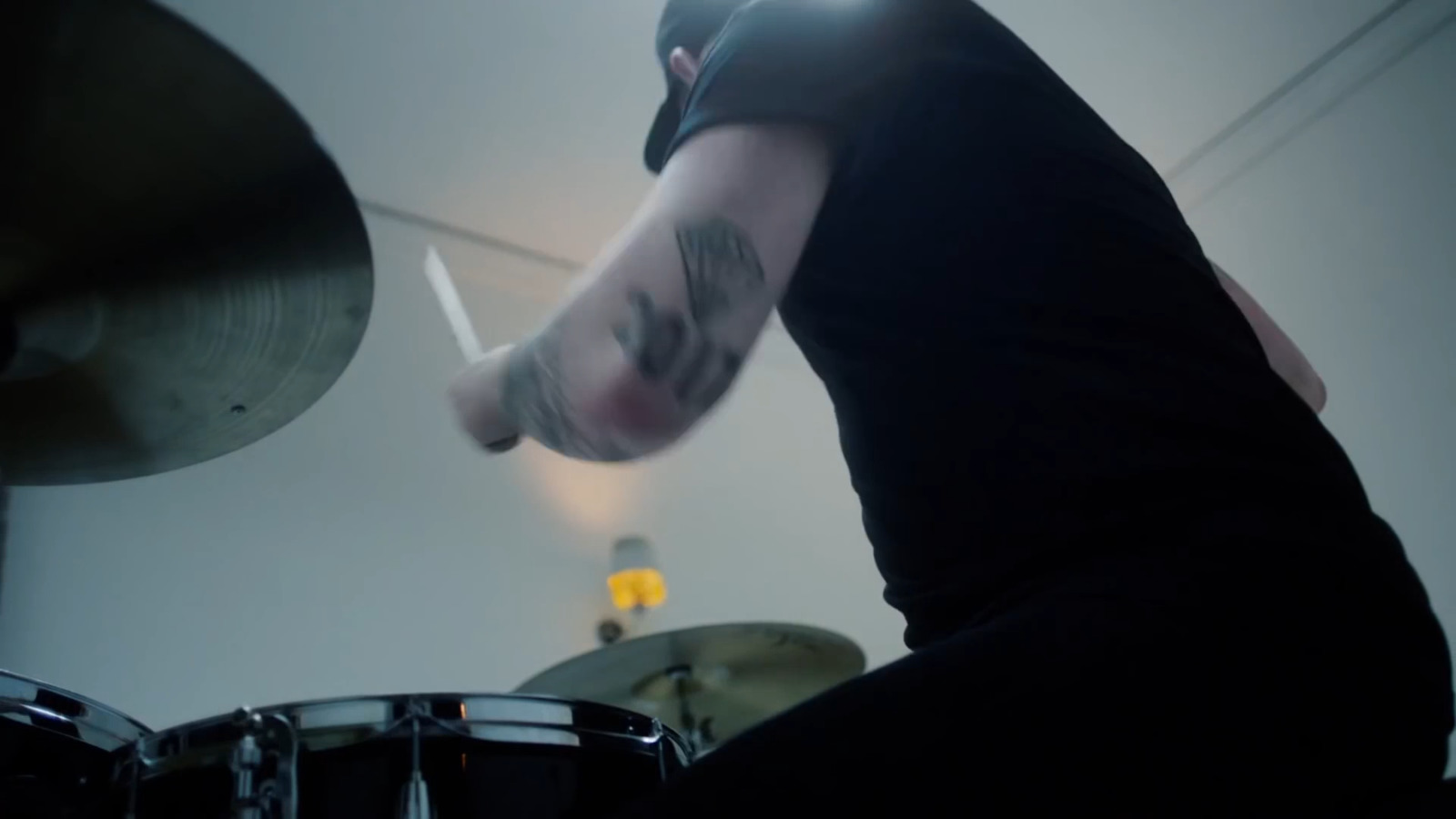 a man in a black shirt is playing drums