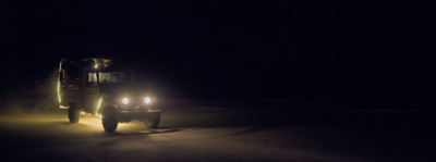 a truck driving down a road at night