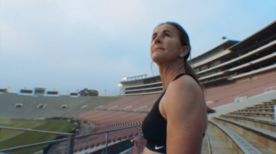 a woman standing in front of an empty stadium