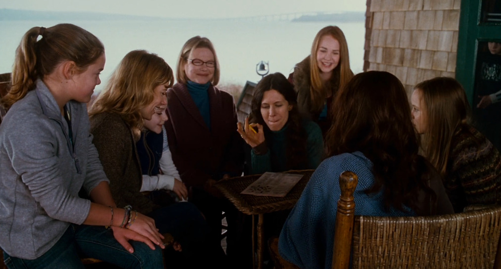 a group of women sitting around a table talking