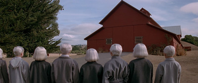a group of people standing in front of a red barn