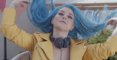 a woman with blue hair wearing headphones