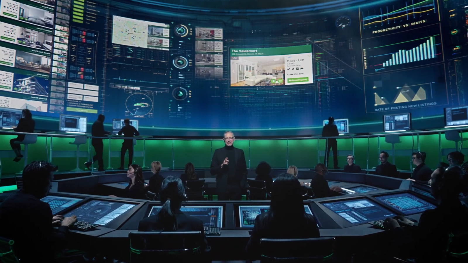 a group of people sitting around a table in front of monitors