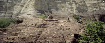 a group of people standing on top of a cliff