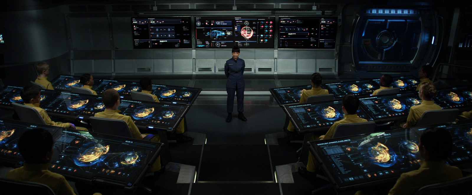 a man standing in front of a bunch of computer monitors