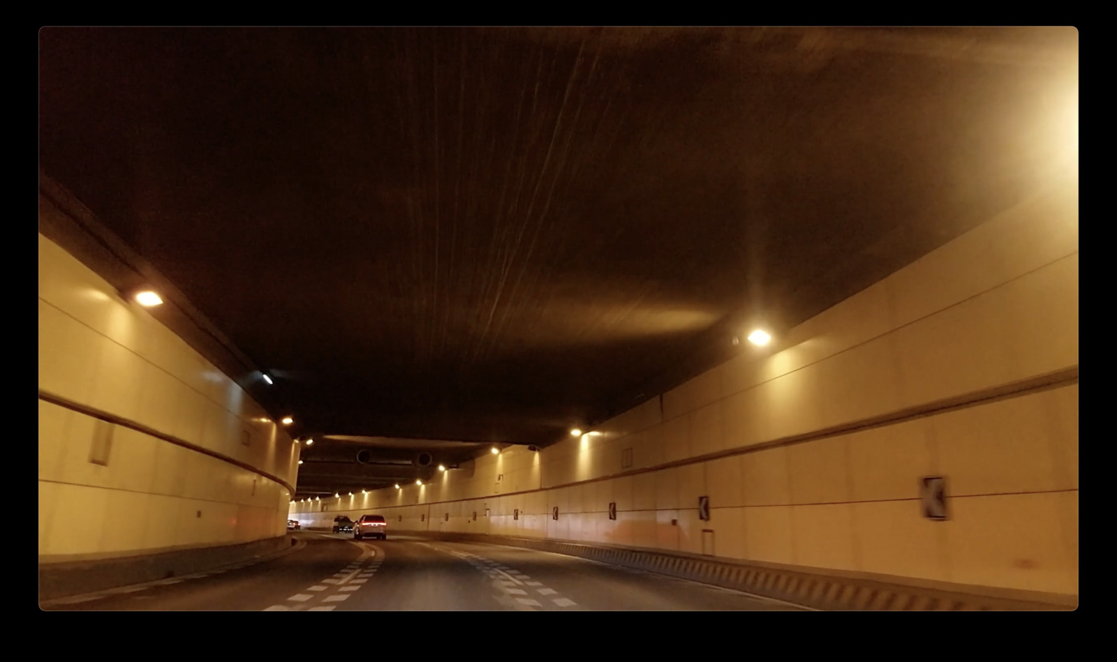 a car driving down a tunnel at night