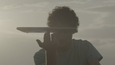 a man holding a surfboard in front of his face