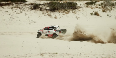 a truck driving through the sand in the desert