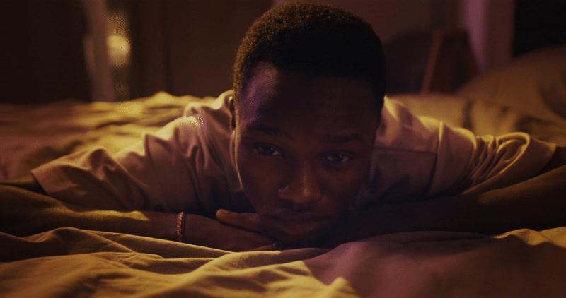 a man laying on top of a bed under a blanket