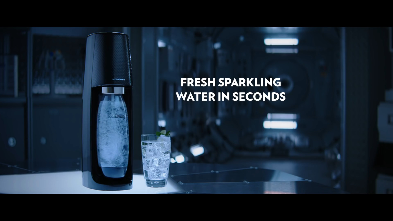 a bottle of water sitting next to a glass