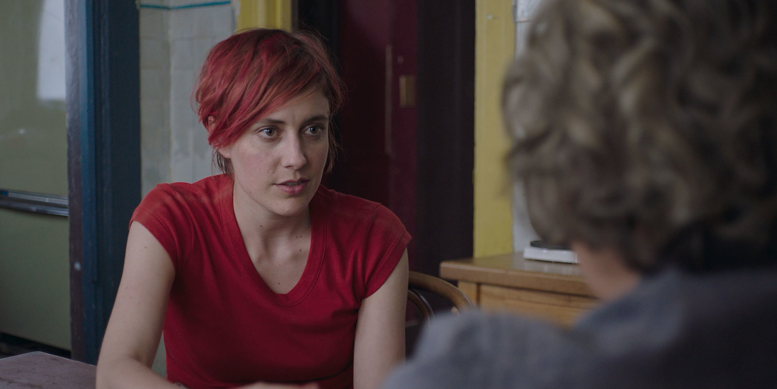 a woman with red hair sitting at a table