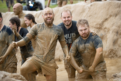 a group of men in mud suits playing in a muddy field