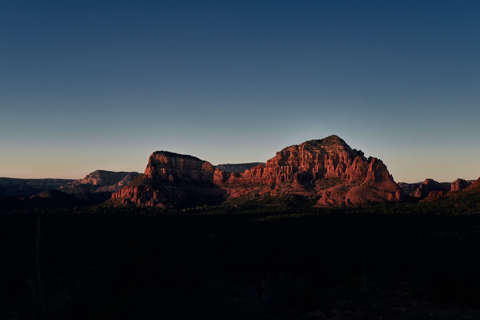 the sun is setting over the mountains in the desert