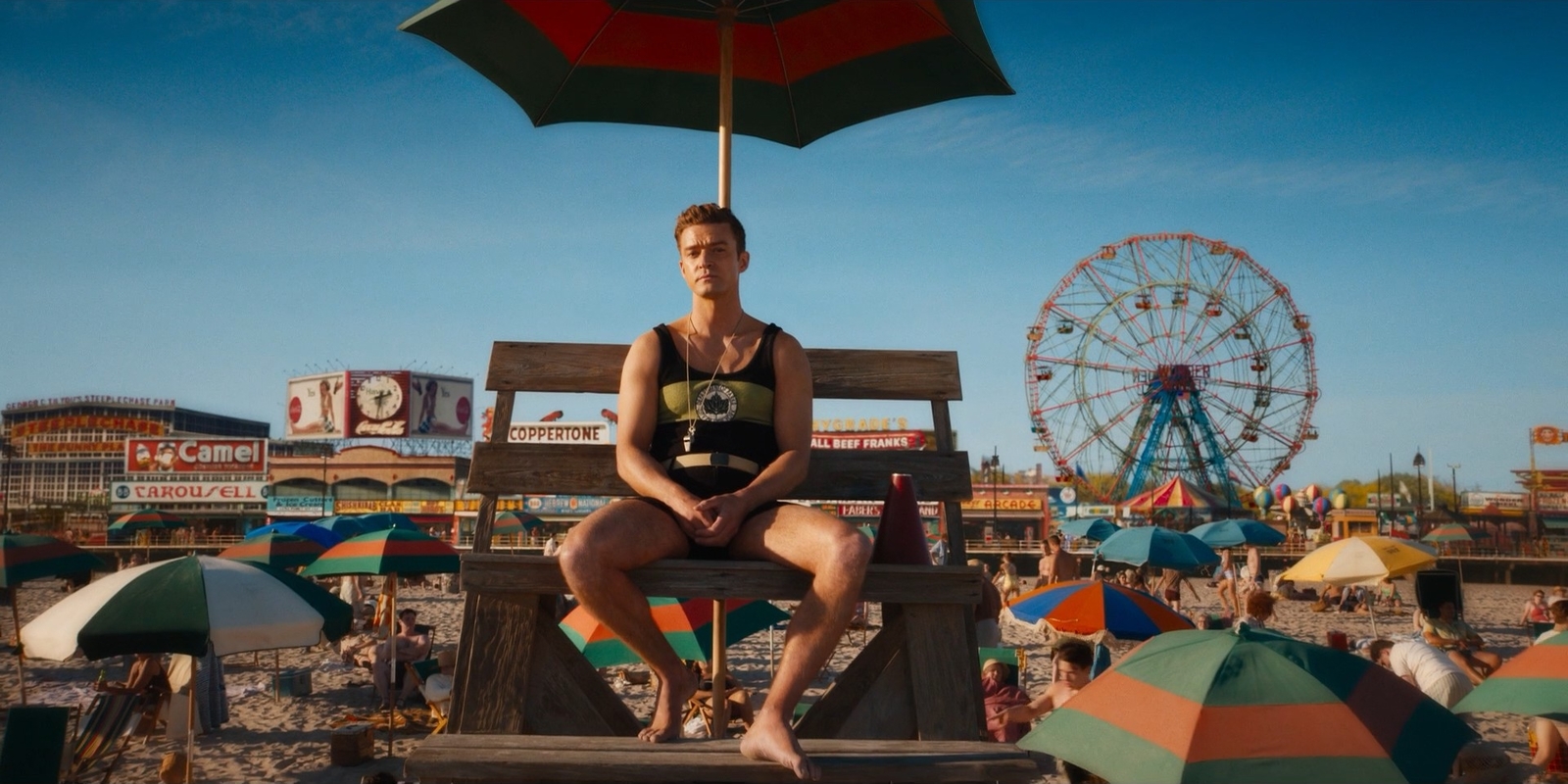 a woman sitting on a bench in front of a ferris wheel