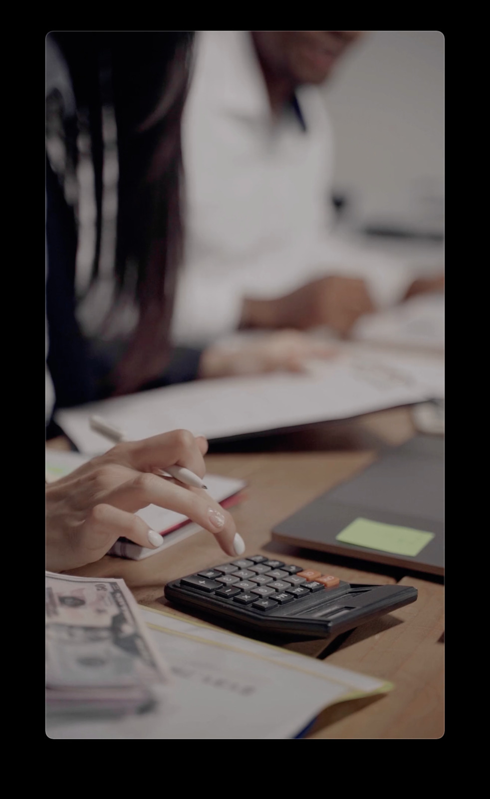 a person sitting at a desk with a calculator