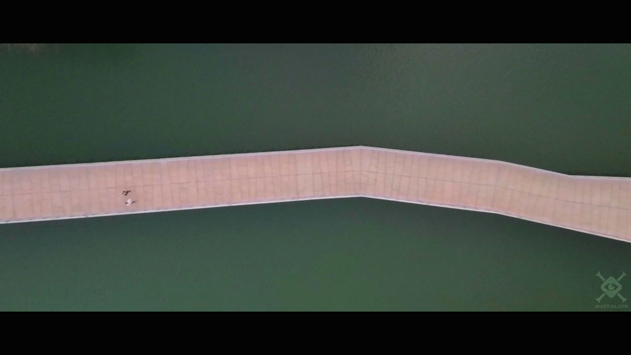 an aerial view of a man riding a skateboard down a ramp