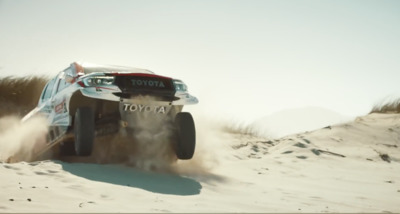 a car driving through the sand on a sunny day