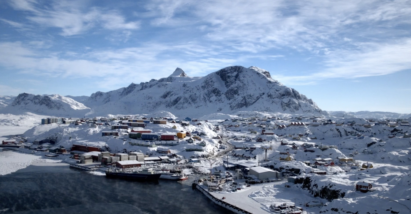 a snow covered mountain with a small town in the foreground