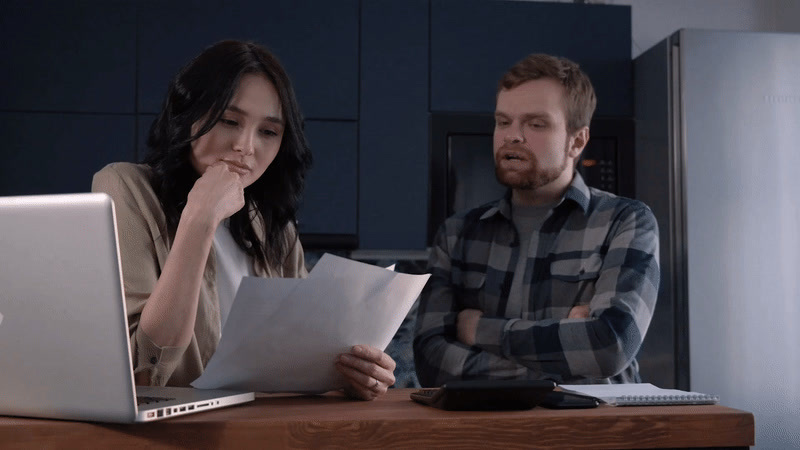 a man and a woman sitting at a table with a laptop