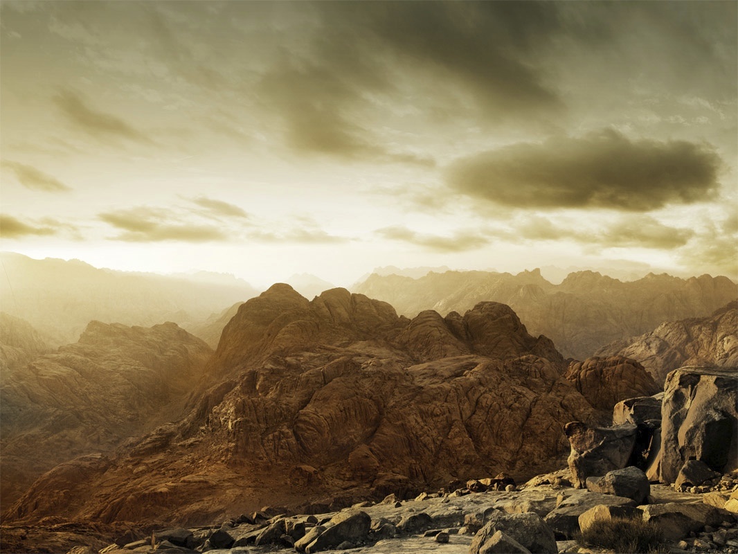 a rocky mountain landscape with rocks and boulders under a cloudy sky