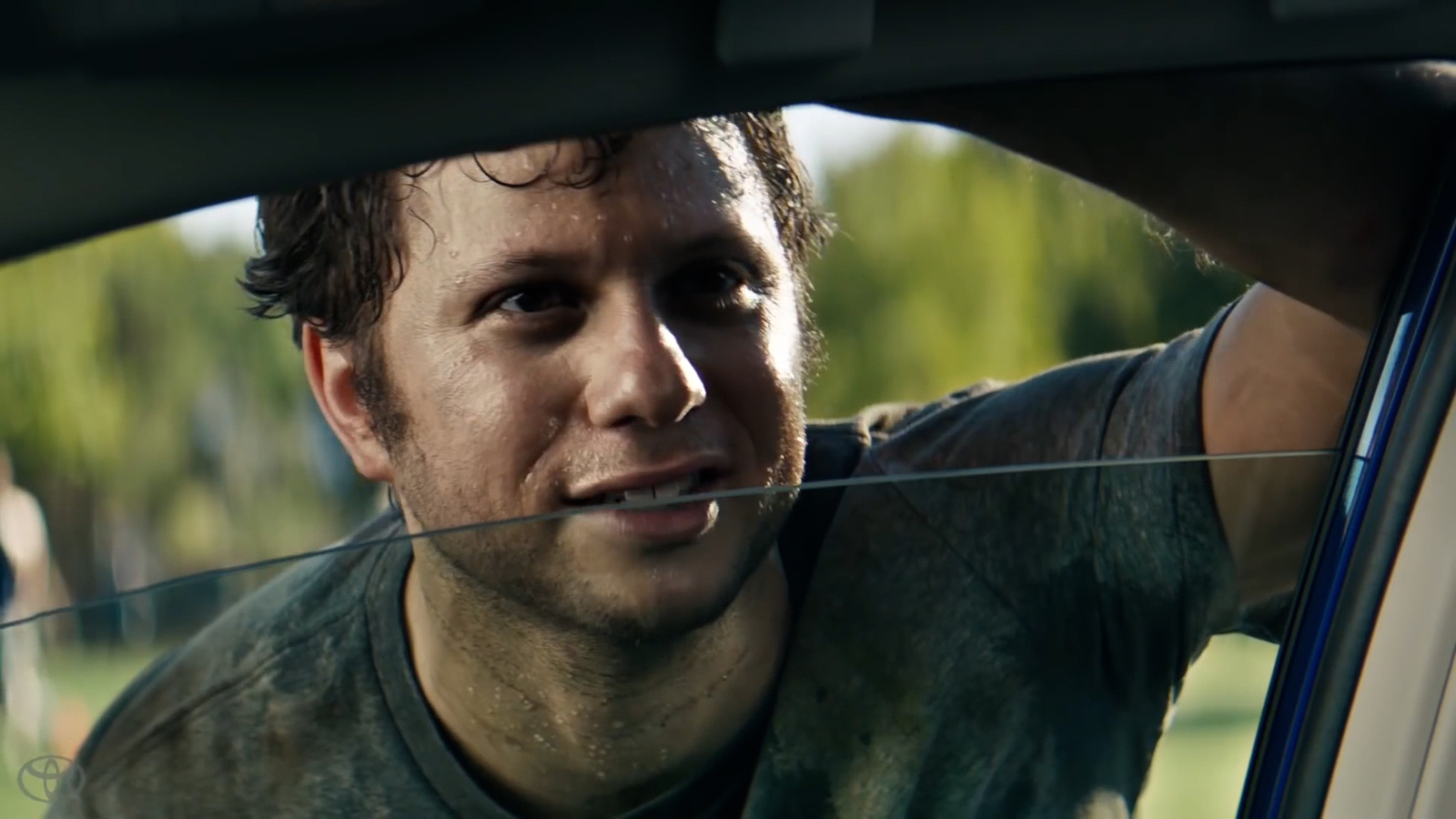 a man sitting in a car looking out the window