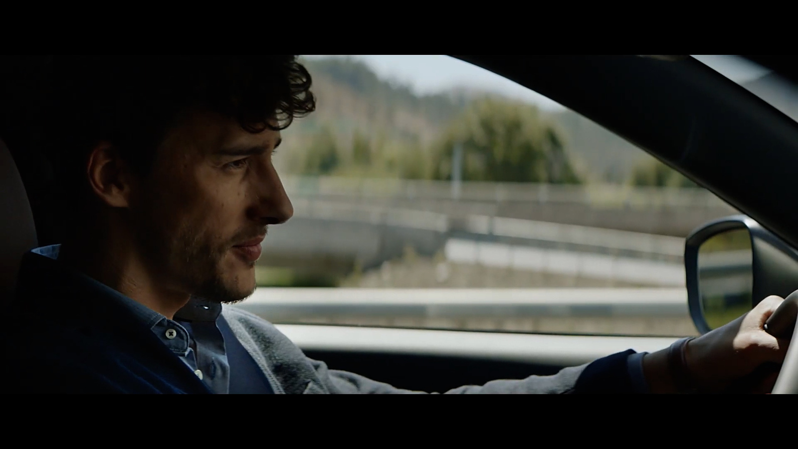 a man driving a car on a highway