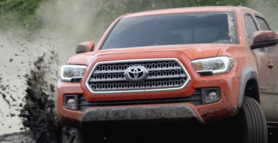 a red truck driving down a muddy road