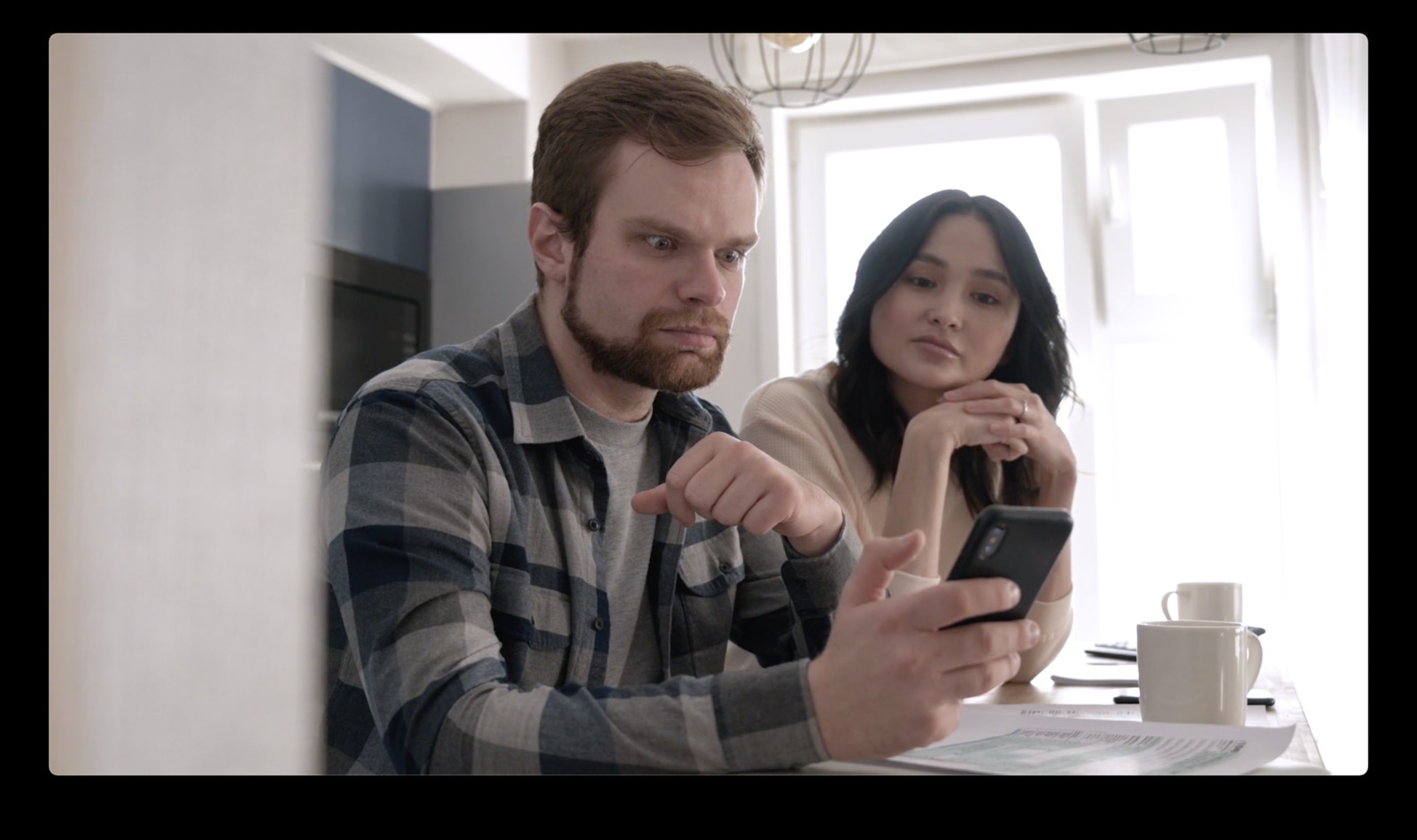 a man and a woman looking at a cell phone