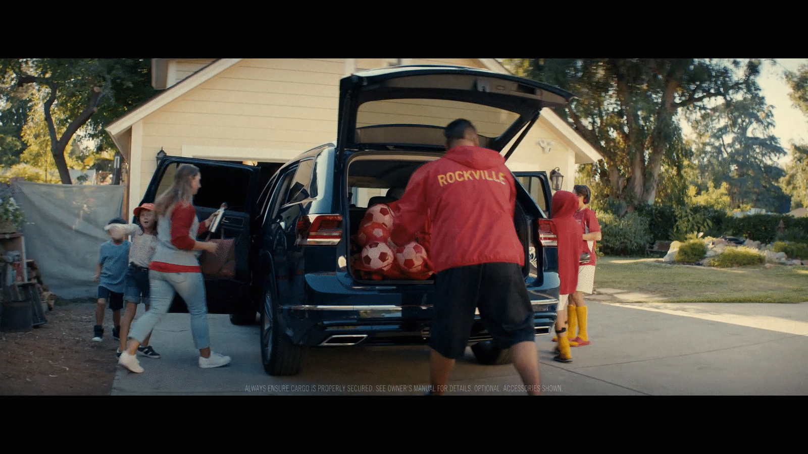 a group of people loading a car into the back of a house