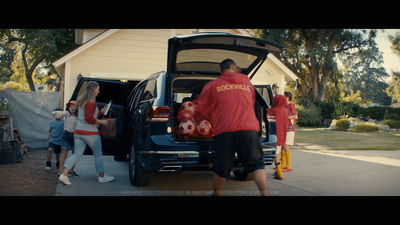 a group of people loading a car into the back of a house