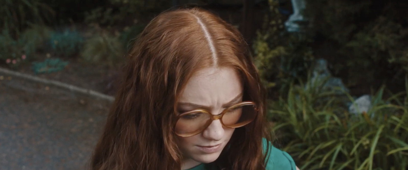 a woman with glasses looking at her cell phone