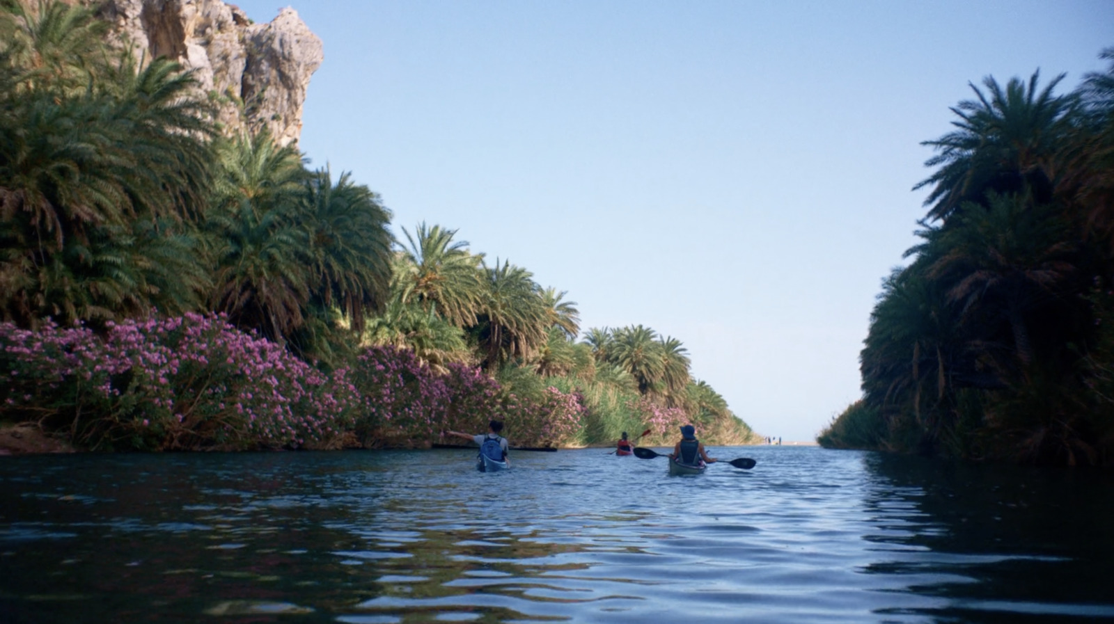 a group of people paddling down a river