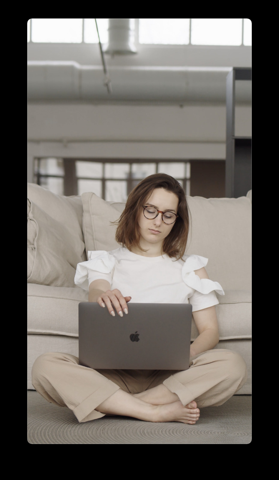 a woman sitting on the floor with a laptop