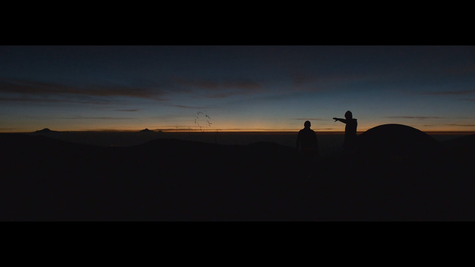 a couple of people standing on top of a mountain