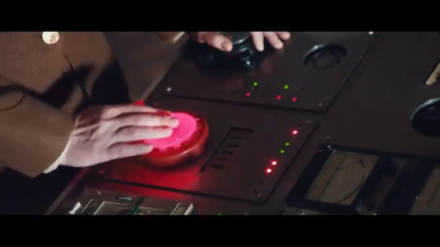 a person in a suit is touching a button on a control panel