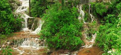 a large waterfall surrounded by lush green trees